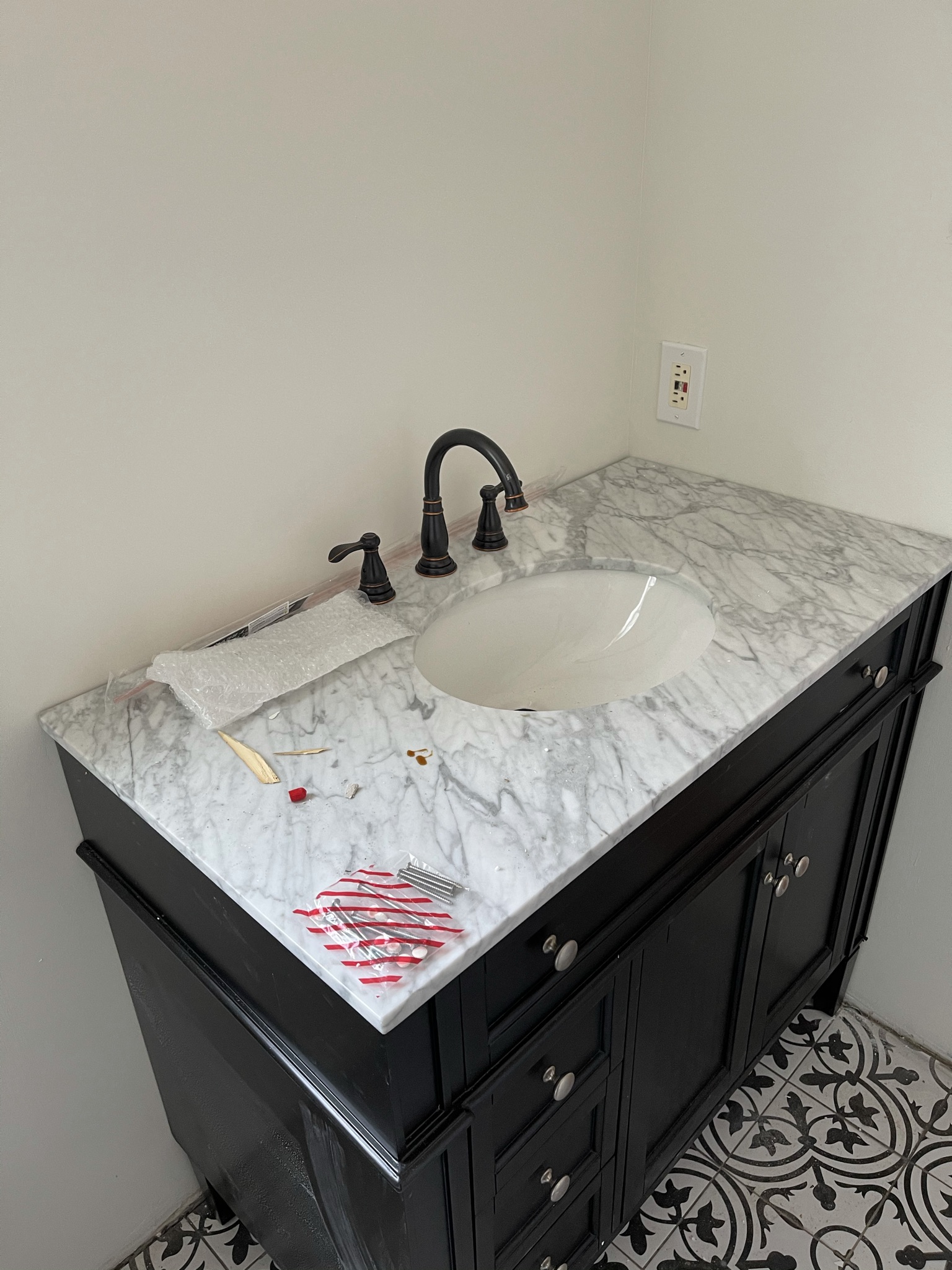 Black vanity with marble countertop and oil-rubbed bronze fixtures
