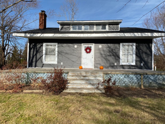 Exterior after — new dark gray siding, new roof, fresh trim